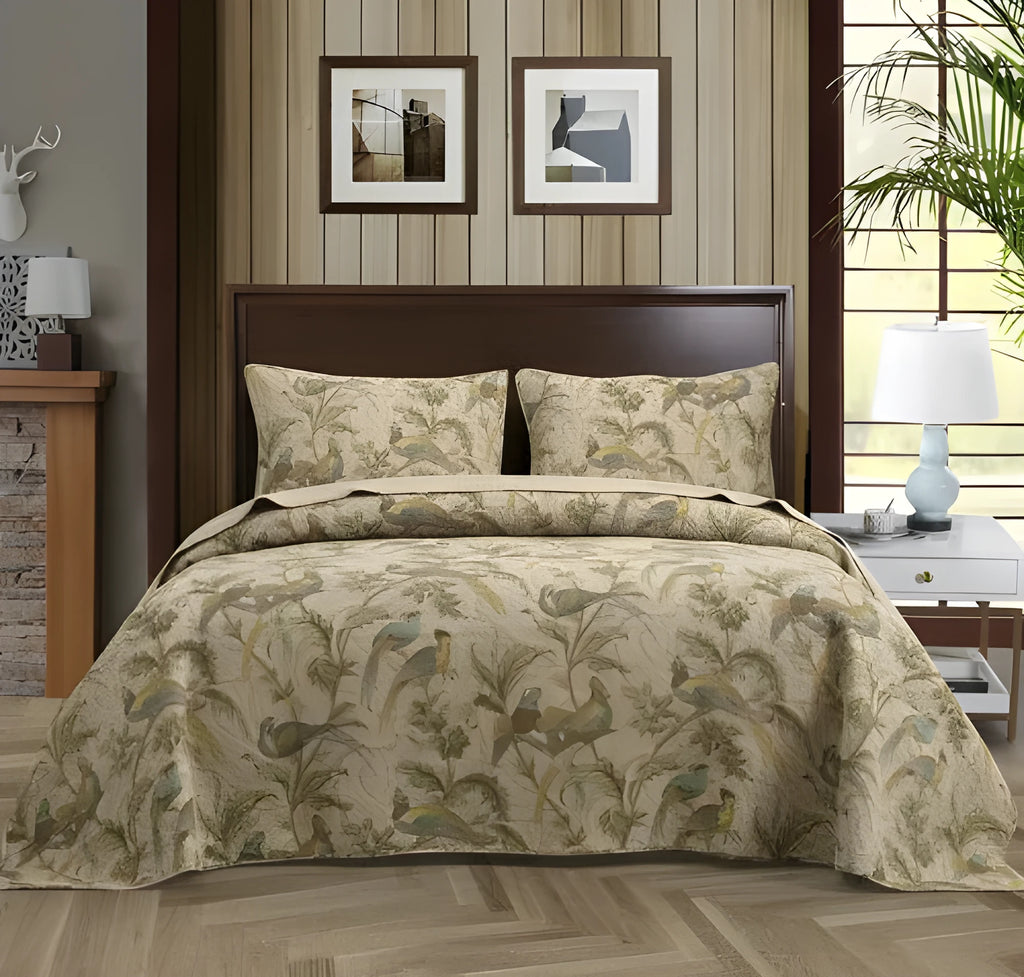 Blue cotton bedspread set with American floral and bird pattern laid on a bed.