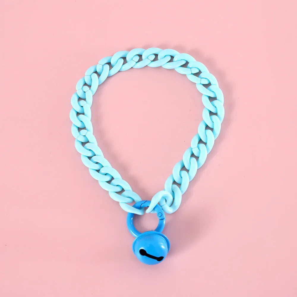 Adjustable plastic pet collar in macaron candy colours on a table, showing chain blue, pink, and mixed colour variants.