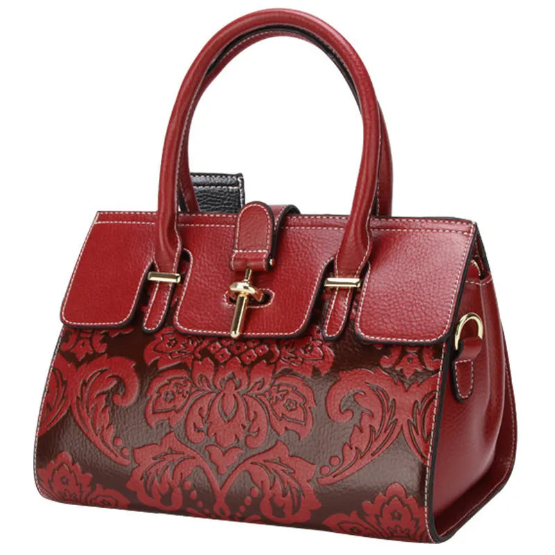 Red genuine leather women's crossbody bag with oval shape and embossed detailing.