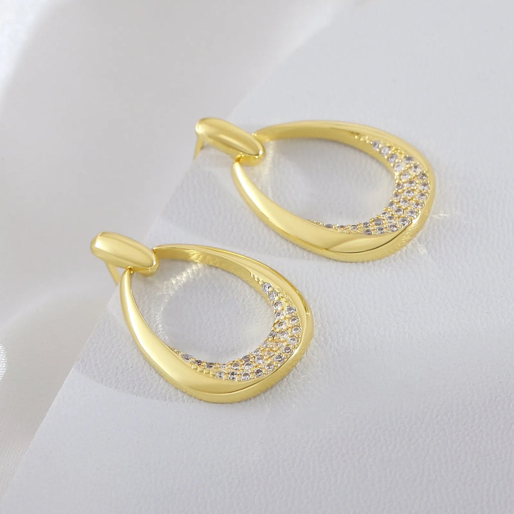 Women's yellow gold geometric drop earrings with simple zircon detail showing oval and round design elements