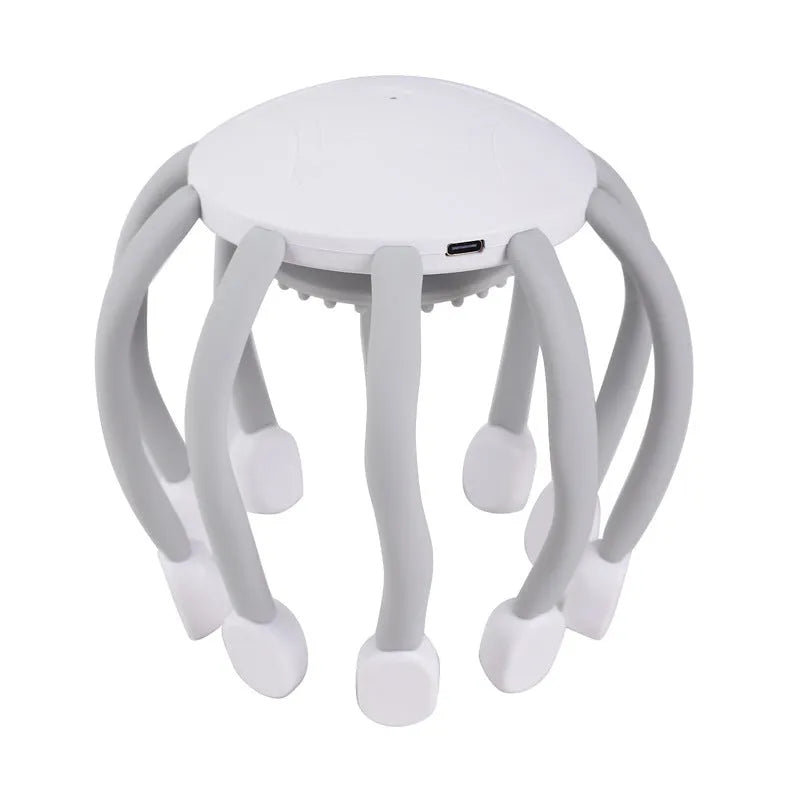 Black handheld electric scalp massager with multiple flexible silicone claws vibrating on a scalp.