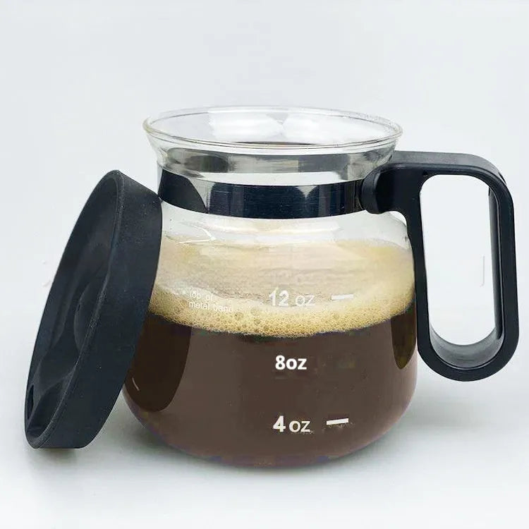 Transparent borosilicate glass coffee maker with black silicone thermal cover on a kitchen counter.