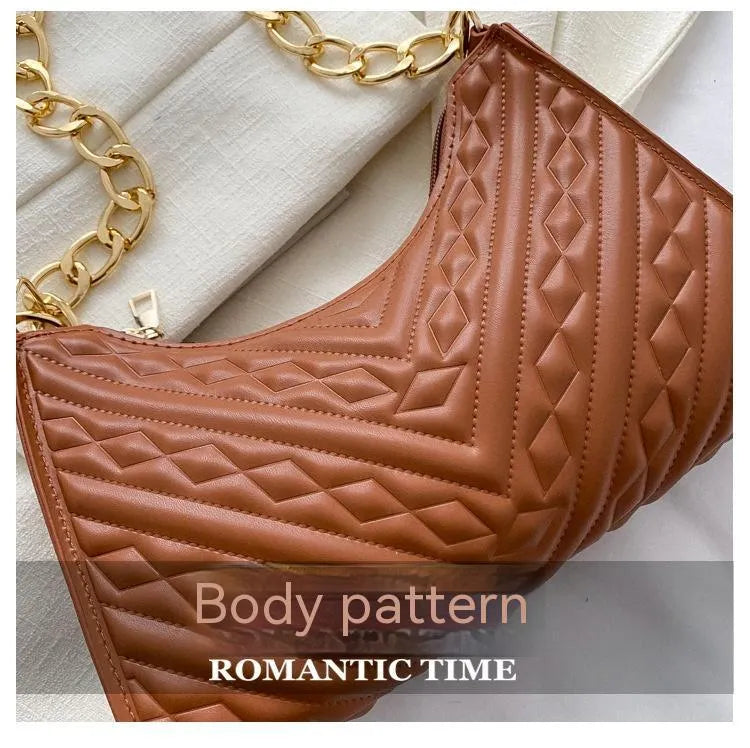 Black pleated chain baguette shoulder bag with adjustable strap and soft handle on white background