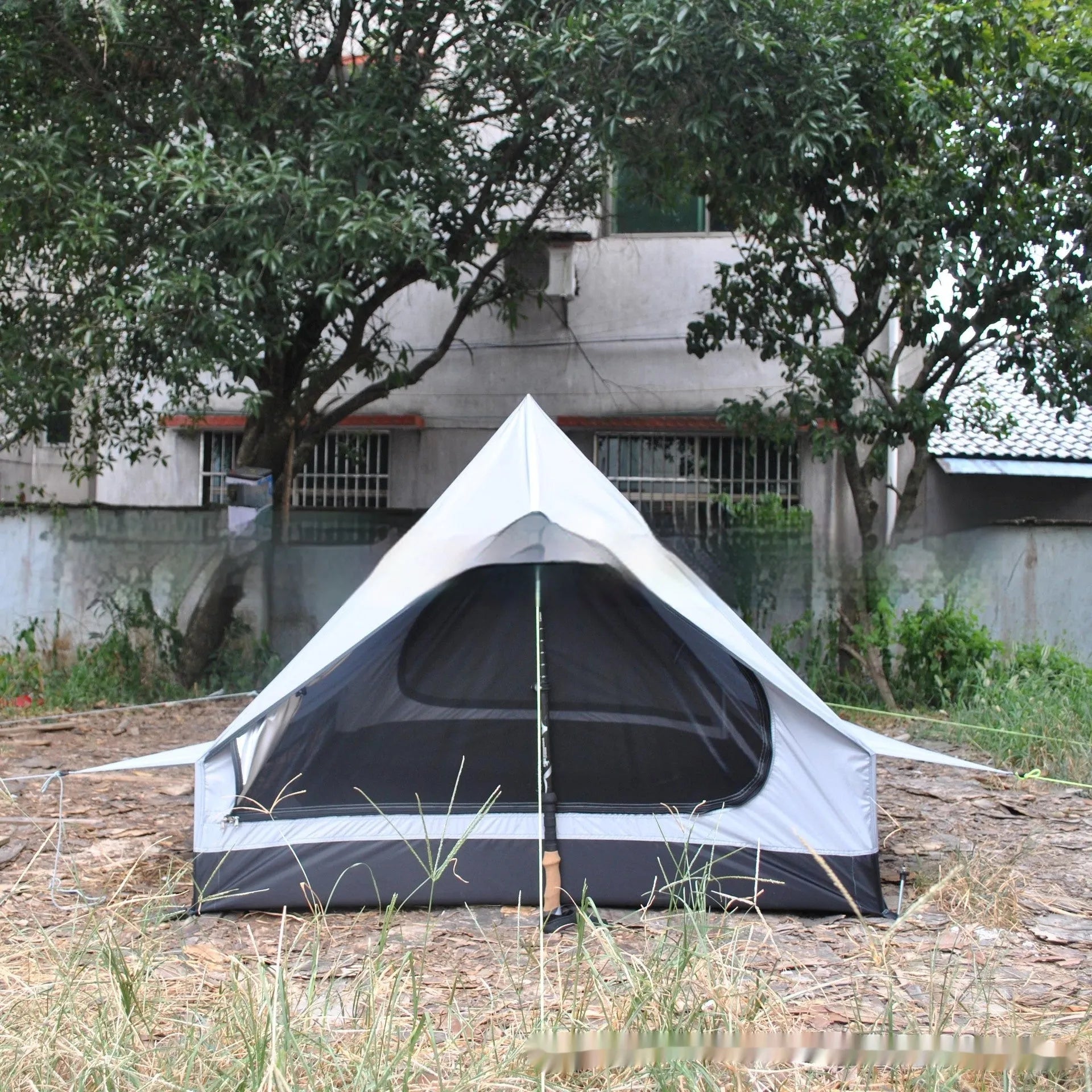 Brown or white A-line pole-free tent pitched with hiking canes showing 210x150x110cm dimensions