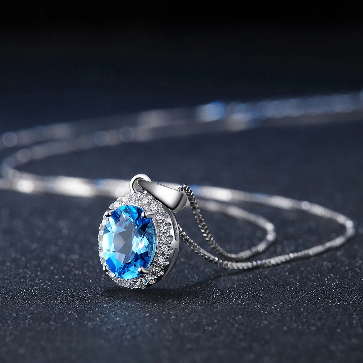 925 sterling silver jewellery set with blue topaz gems showing earrings, ring, pendant, and necklace with geometric design