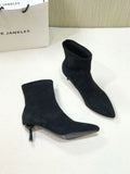 Black pointed toe ankle boots with a stiletto heel on a white background