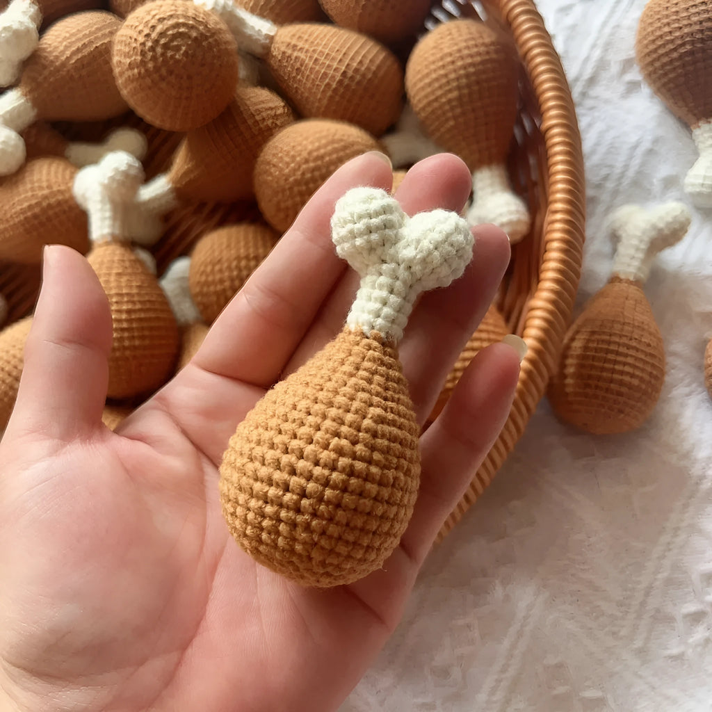Crocheted chicken leg pendant key chain made of soft plush material, about 8 cm long, on a plain background