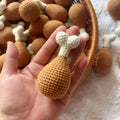 Crocheted chicken leg pendant key chain made of soft plush material, about 8 cm long, on a plain background