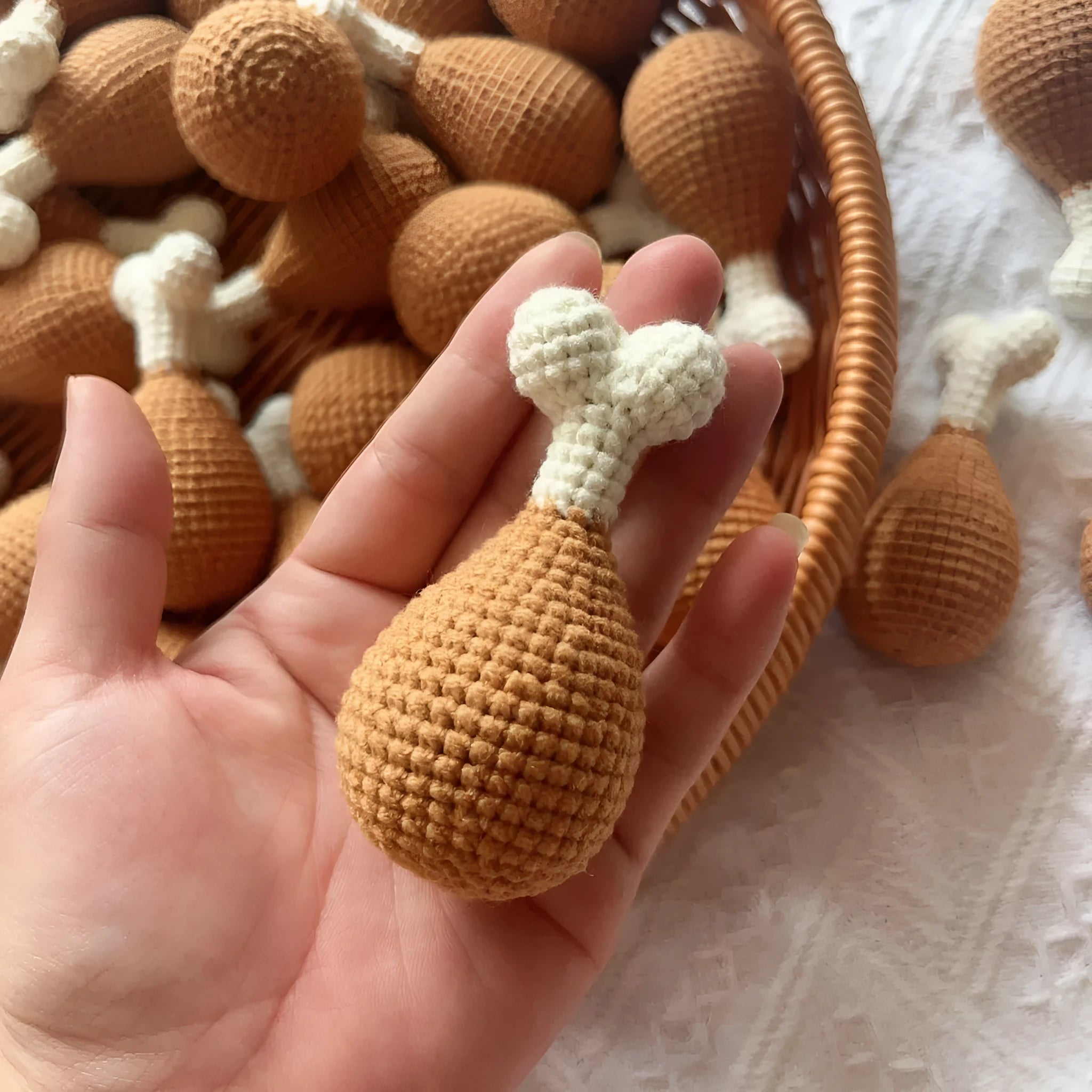 Crocheted chicken leg pendant key chain made of soft plush material, about 8 cm long, on a plain background