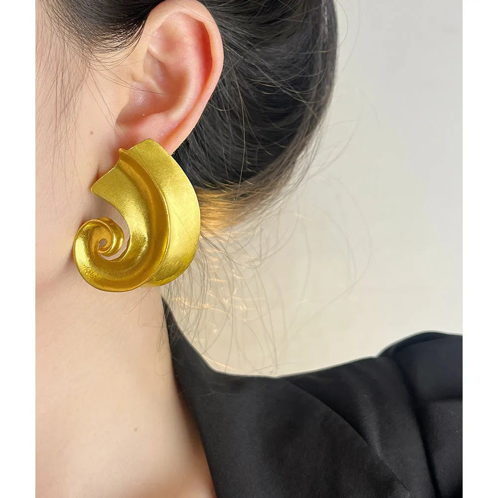 A pair of geometric-shaped alloy ear studs with a retro design, shown in gold and silver colours on a post backing.