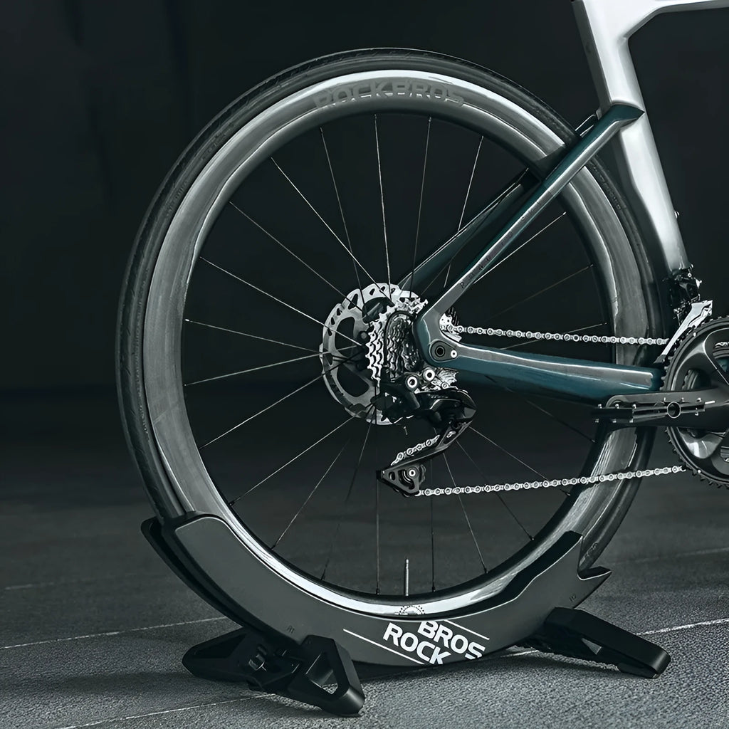 ABS wall-mounted bike parking rack holder in black holding a bicycle frame against a garage wall