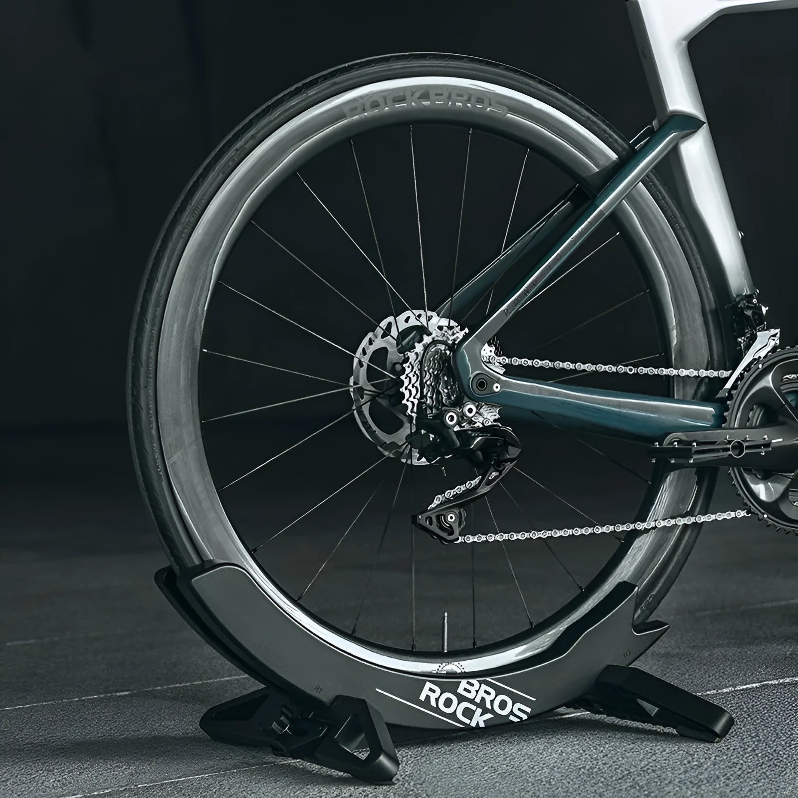 ABS wall-mounted bike parking rack holder in black holding a bicycle frame against a garage wall