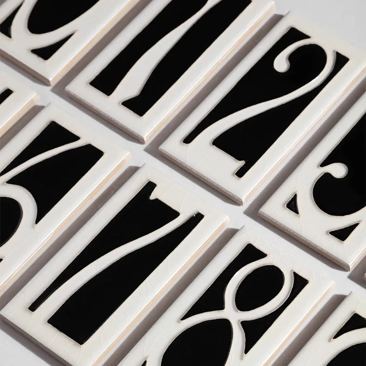 Handmade ceramic door number plaque with retro enamel art design showing style examples