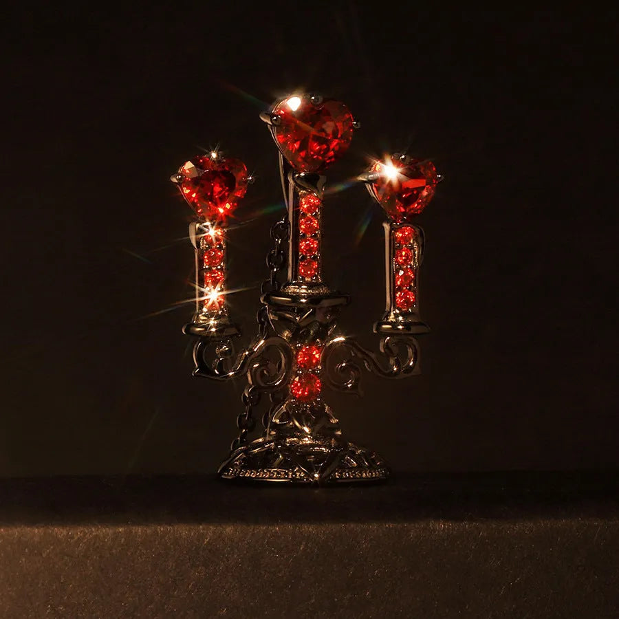 Close-up of a women's Gothic alloy necklace with a hollow candlestick pendant and cross chain links.