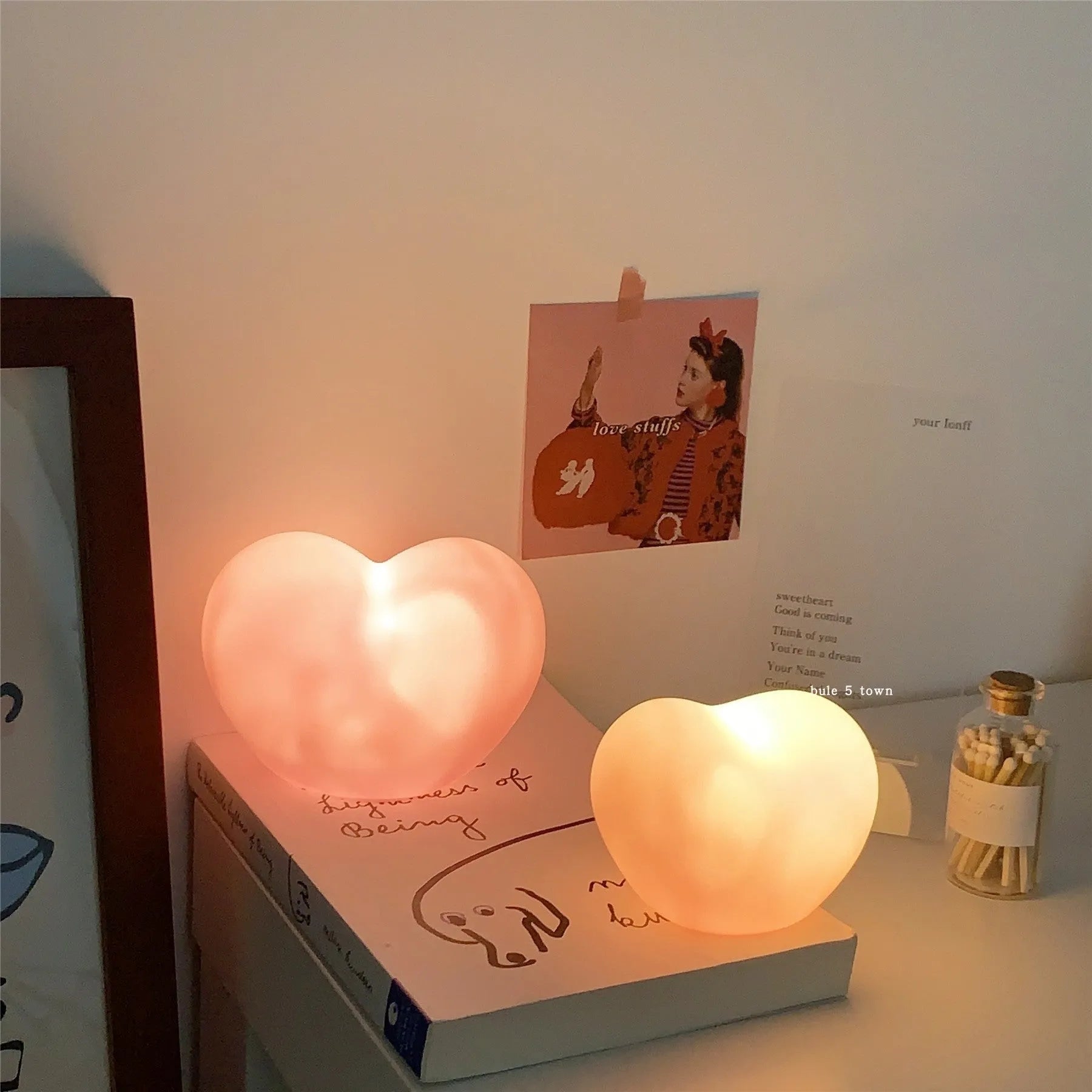 White or pink vinyl atmosphere lamp emitting warm light, shown in small and large size options.