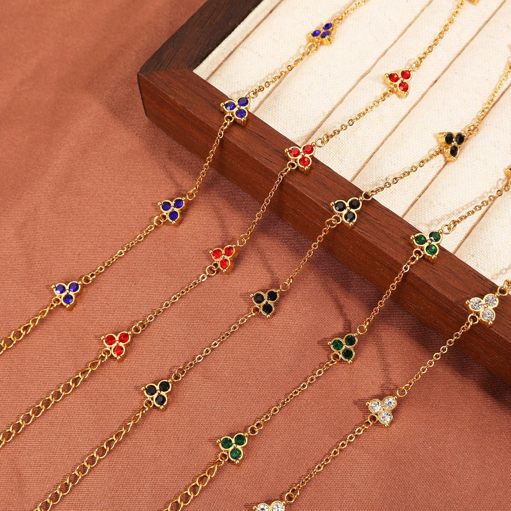 Geometric stainless steel women's bracelet with three diamond shapes and coloured stone settings.