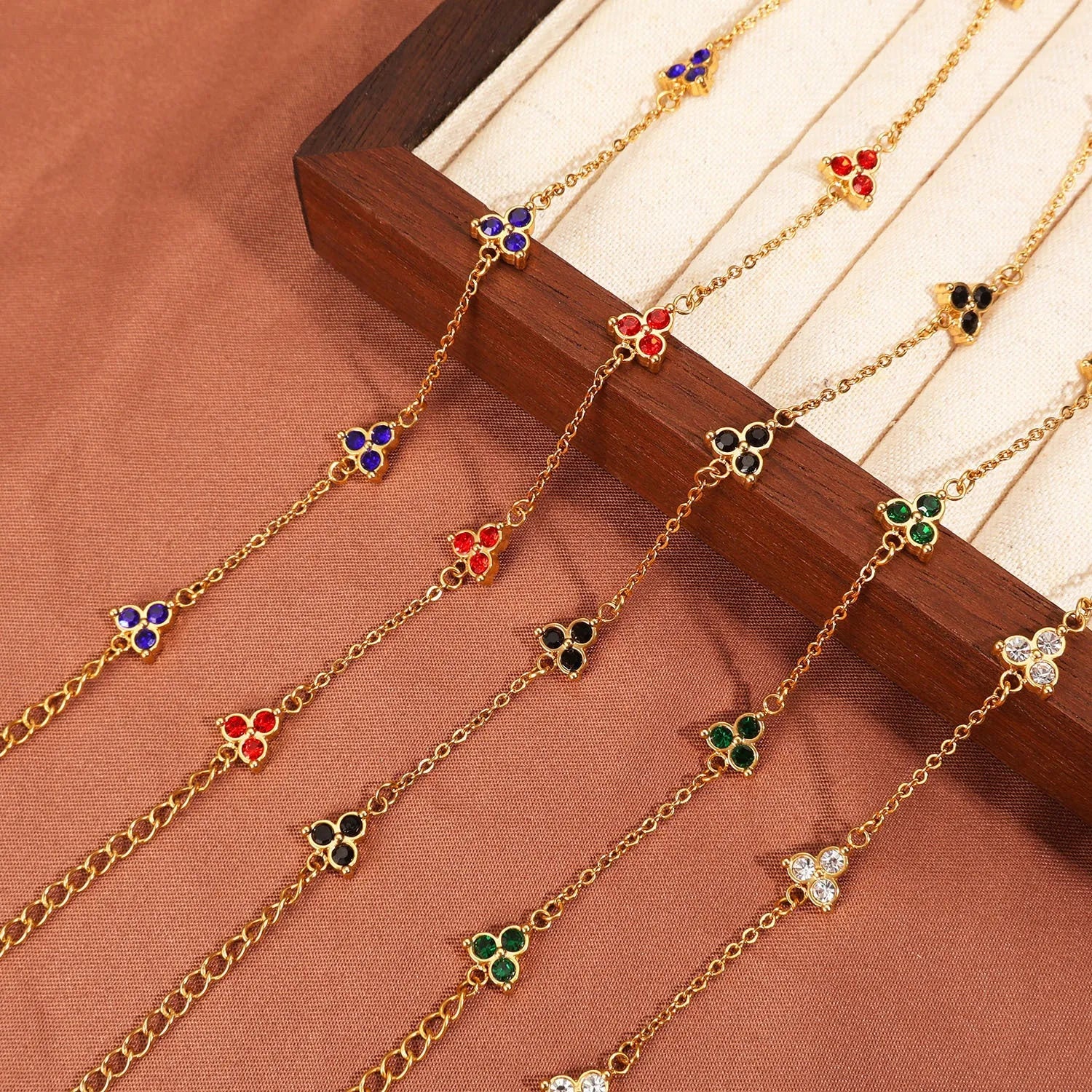 Geometric stainless steel women's bracelet with three diamond shapes and coloured stone settings.