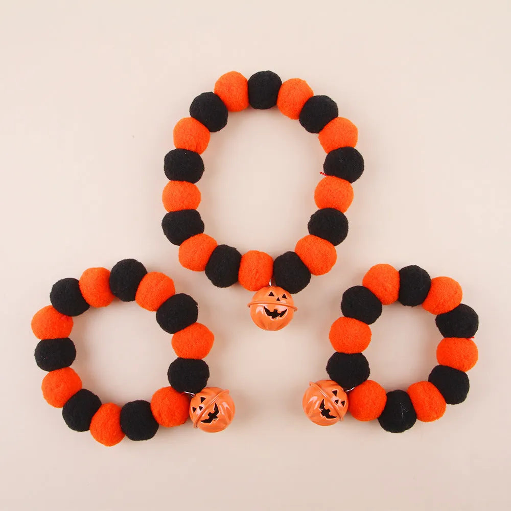 Orange Halloween pet collar for cats with pumpkin pattern and Trick or Treat text, showing plastic buckle.