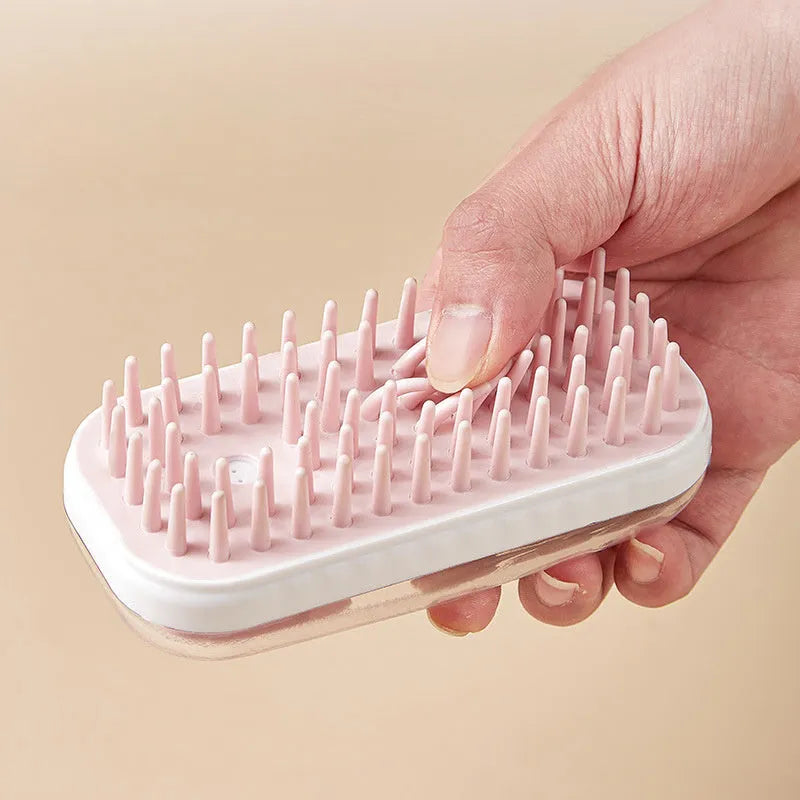 Grey silicone bath brush for pets with soft bristles and ergonomic handle on white background