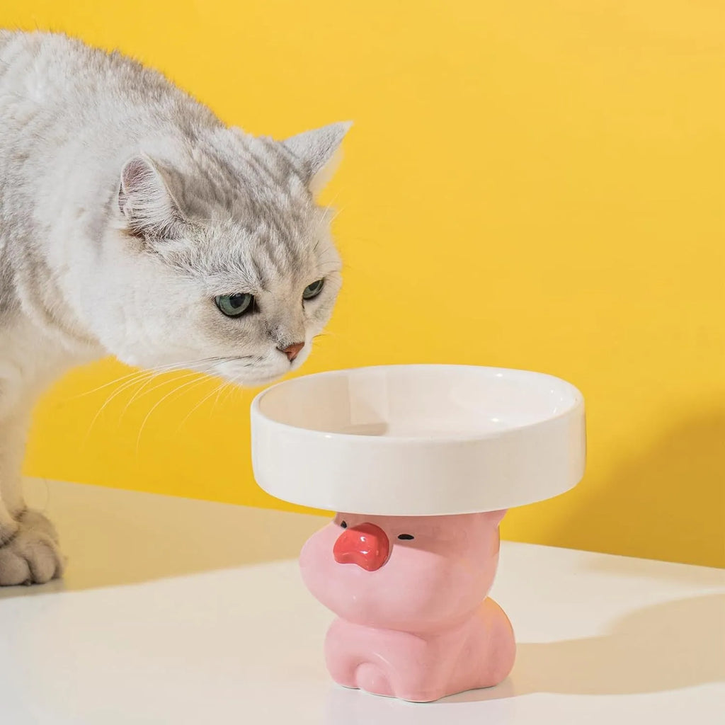 A raised ceramic cat bowl in an animal design, showing its height and wide opening for whisker-friendly feeding.