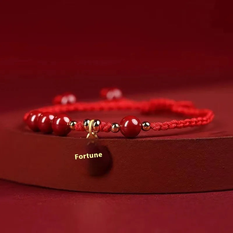 Cinnabar round bead blessing card bracelet with adjustable braided rope on neutral background
