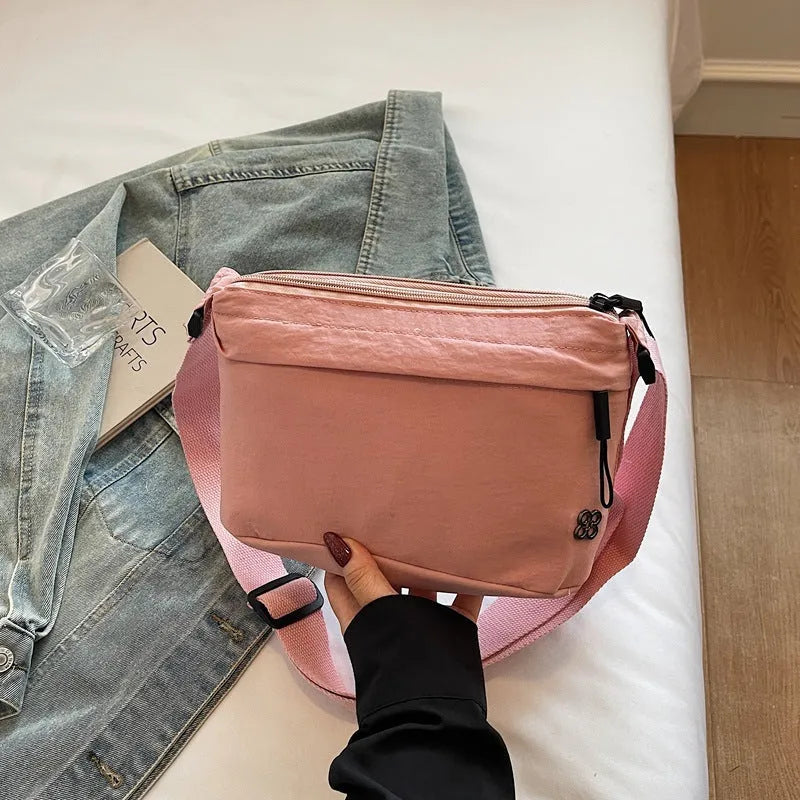 Lightweight cloth crossbody bag in black with horizontal square shape, sandwich pocket, and canvas lining