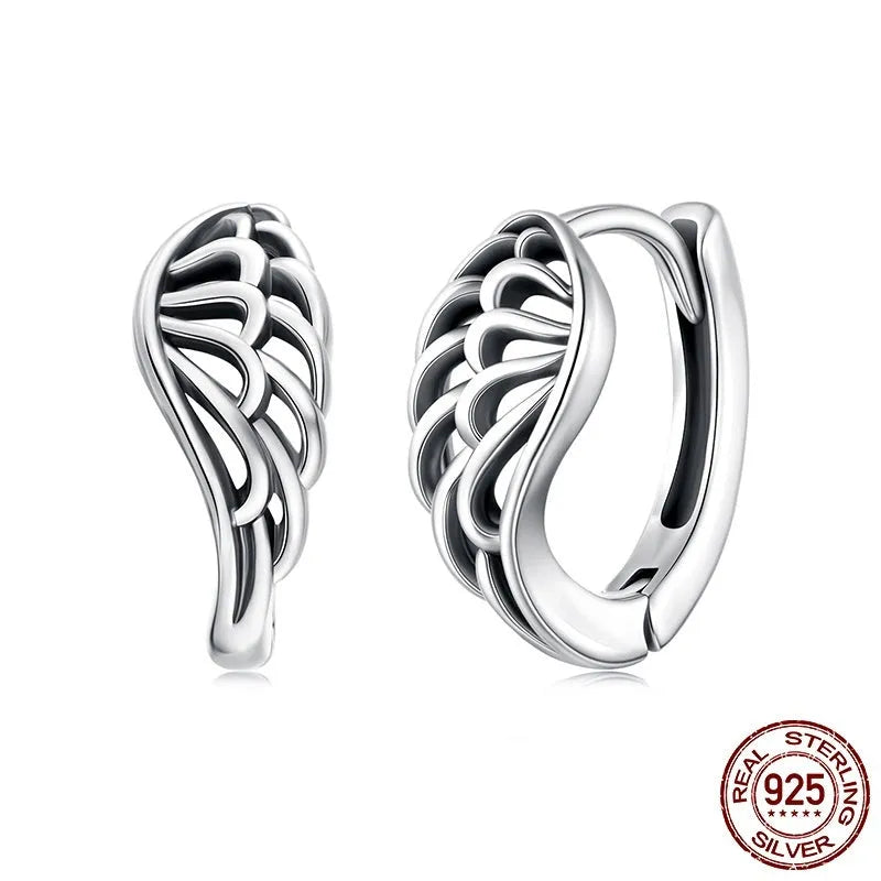 Pair of vintage S925 sterling silver wings ear clip earrings in silver colour on white background