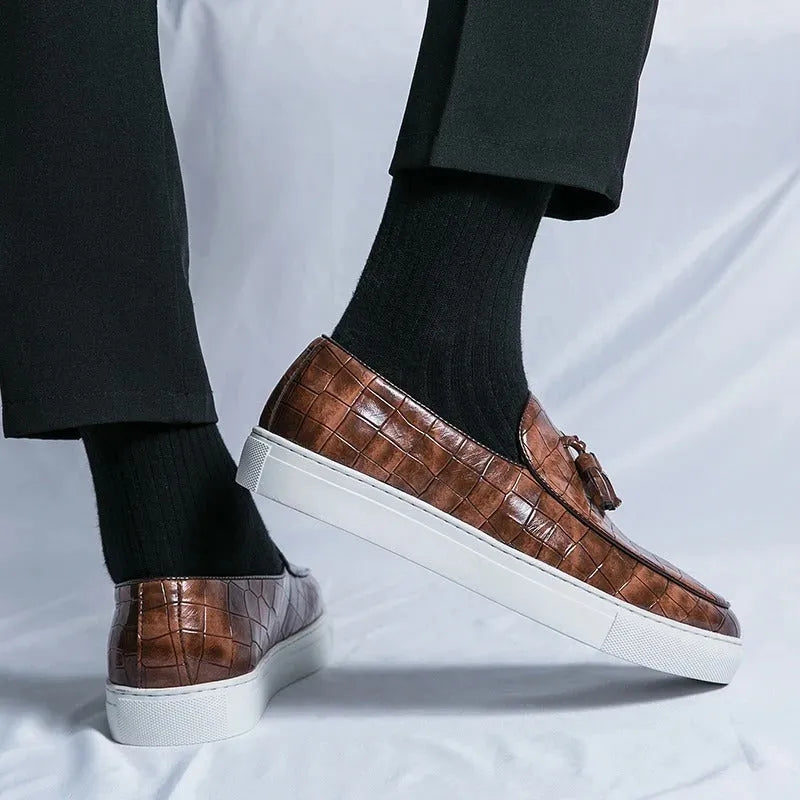 Men's black tassel detail leather-look sneakers on a white background, side view.