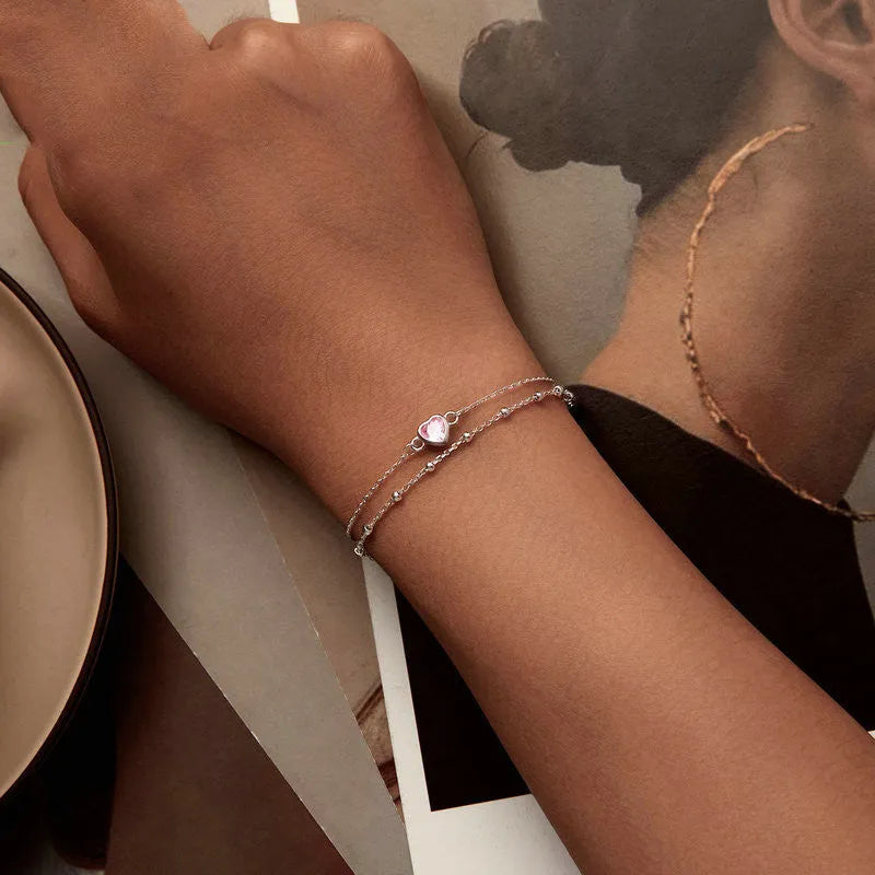 Sweet girlish heart-shaped sterling silver bracelet with adjustable chain on a white background.