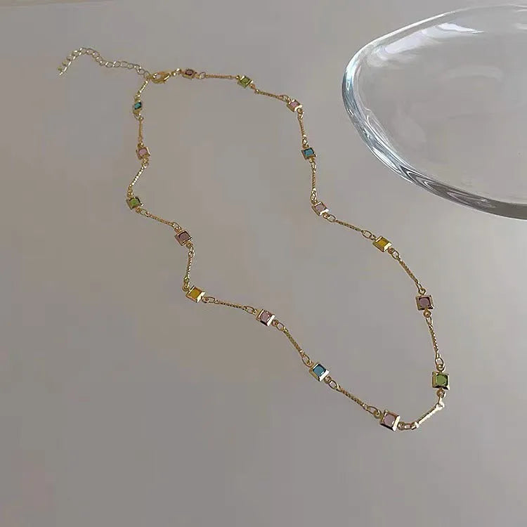 Square colour geometric quadrilateral alloy clavicle chain necklace with artificial crystal details on a model.