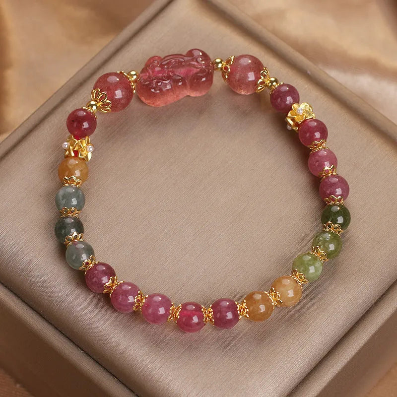 Pink crystal Pi Xiu bracelet with tourmaline and strawberry quartz beads on white background