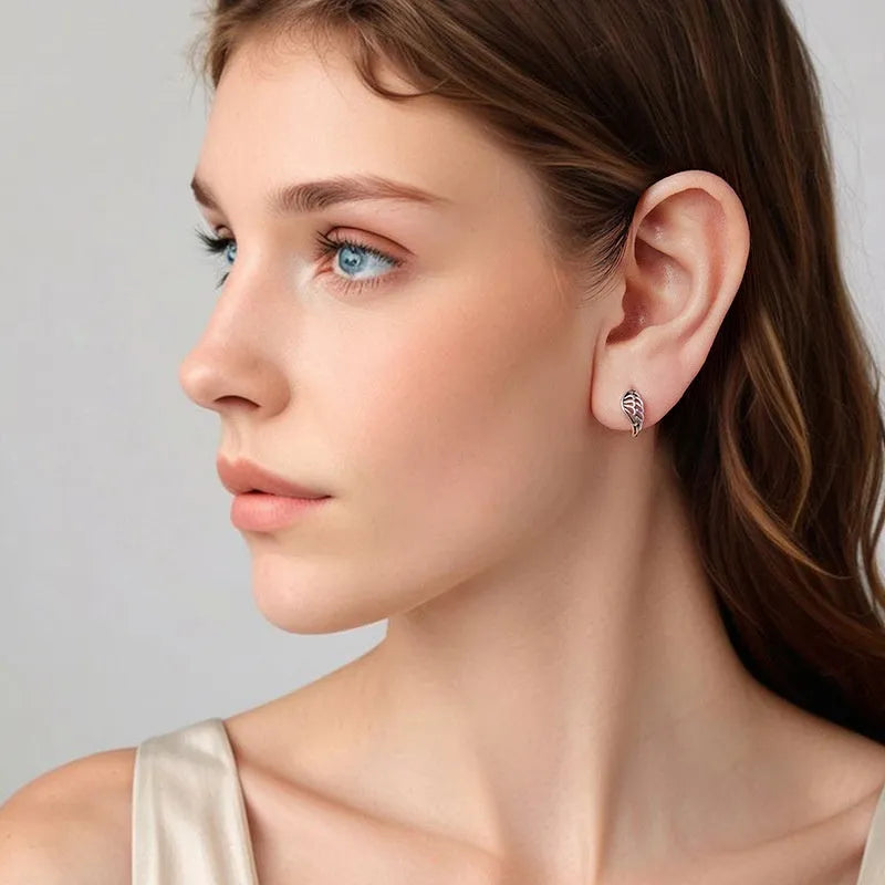Pair of vintage S925 sterling silver wings ear clip earrings in silver colour on white background
