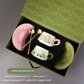 Ceramic coffee cup saucer set with two cups, two plates, and two spoons in matching design