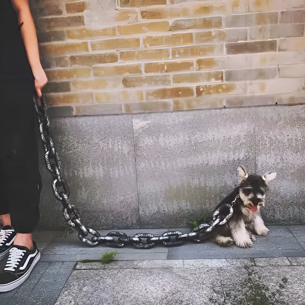 Bronze coloured plastic dog leash simulation prop for video spoofs on a plain background.
