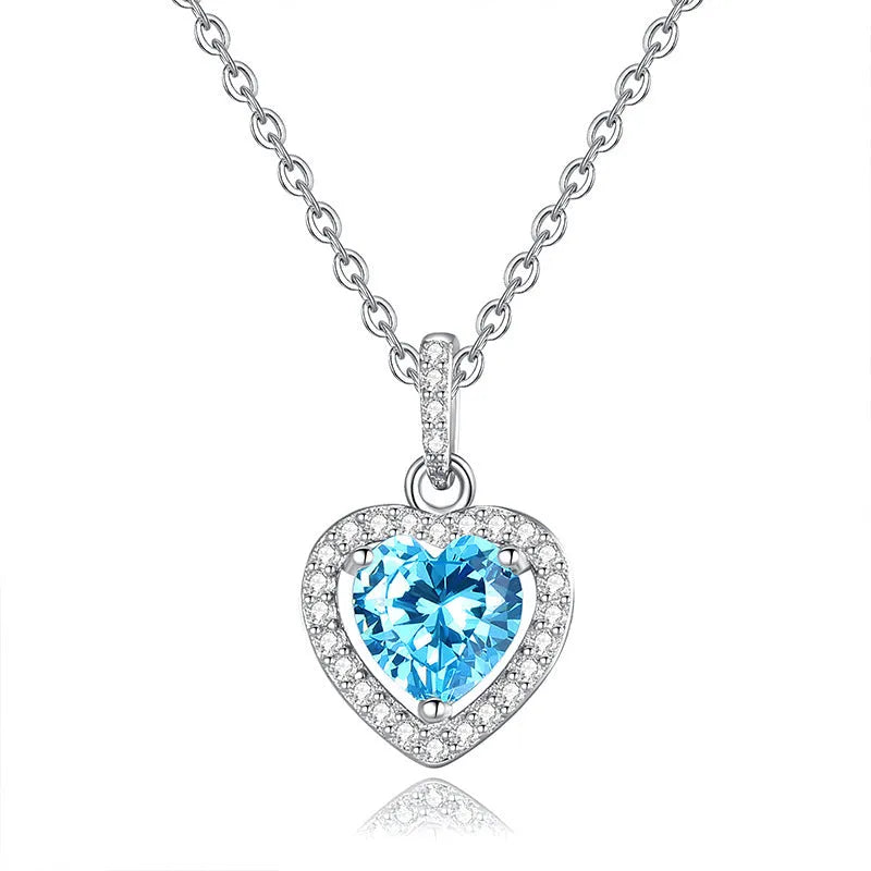 Women's sterling silver heart pendant necklace with a coloured gemstone on an adjustable chain.