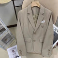 Women's black short suit coat with regular sleeves and pocket detailing