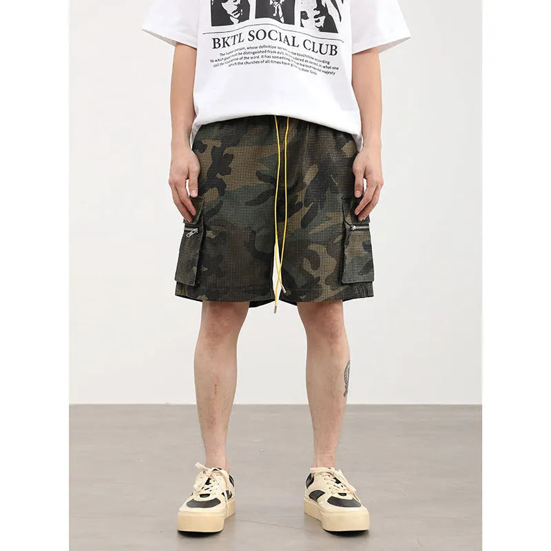 Multi-pocket camouflage workwear shorts for men with mid-waist cropped design and thin fabric, shown in a flat lay.