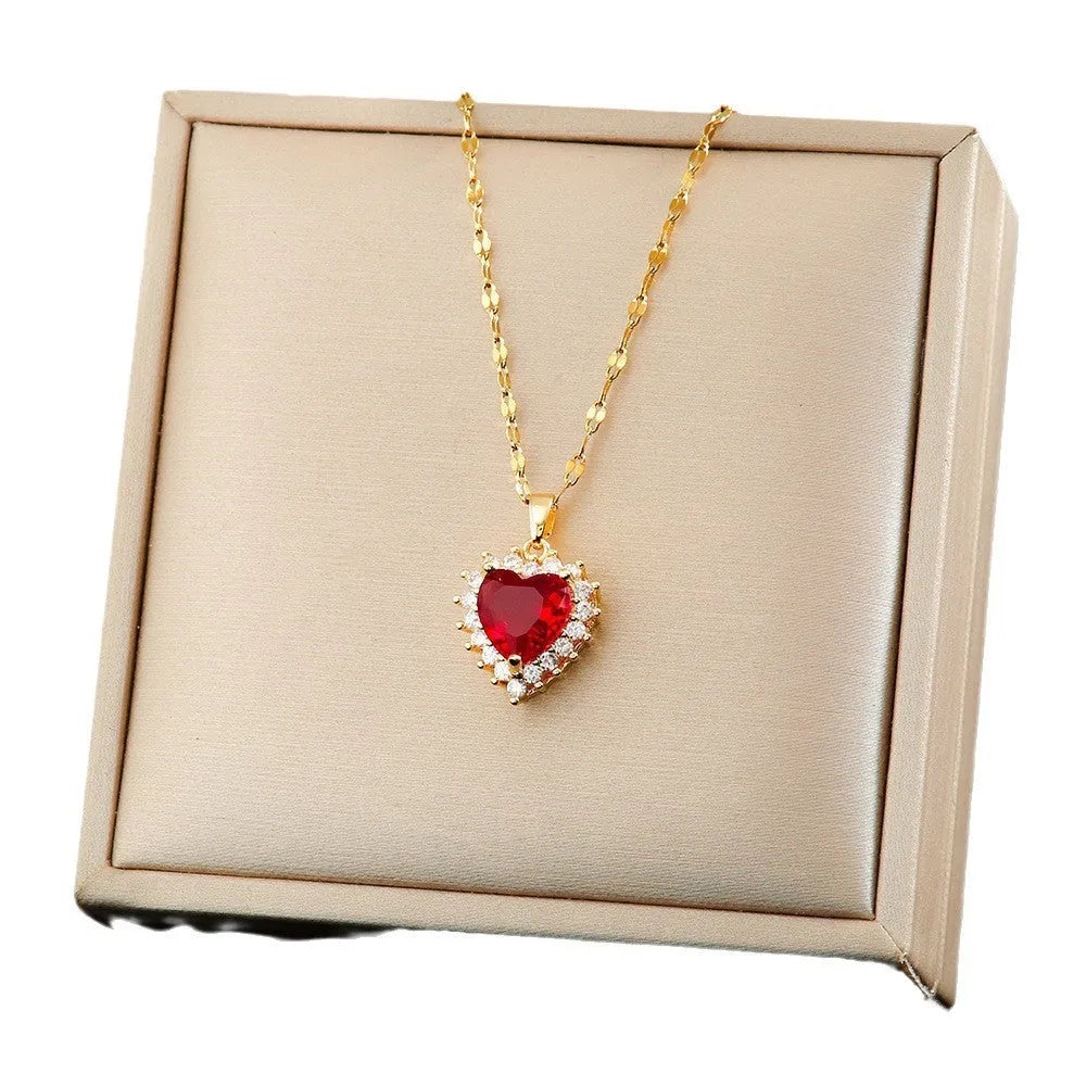 Gold red titanium steel jewellery set with heart and flower pendant, stud earrings, and ring on a water wave chain.