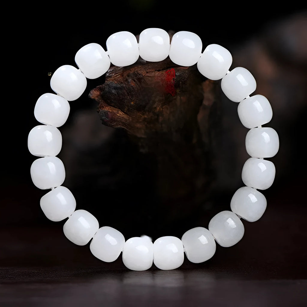 White Hetian jade barrel bead bracelet on a wrist, showing the unisex casual design.
