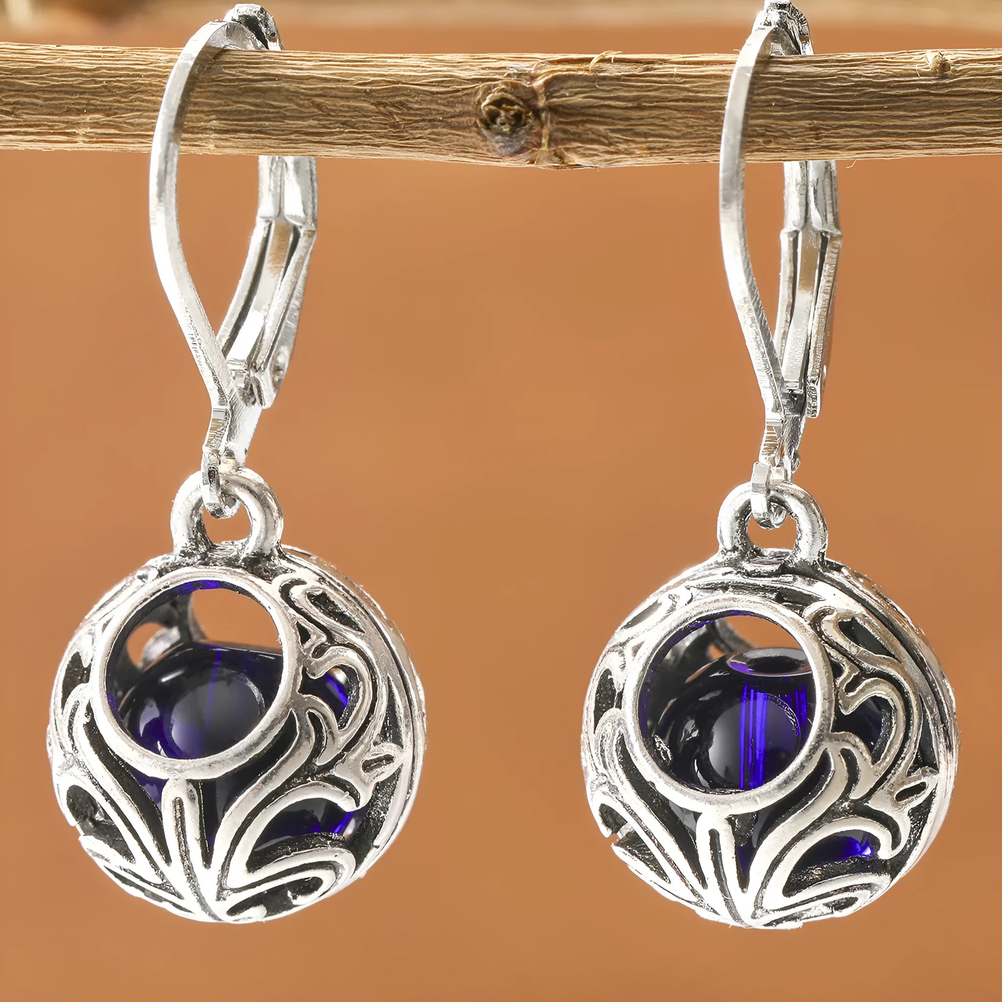 Vintage silver hollow pendant earrings with blue gemstone accent on geometric drop shape