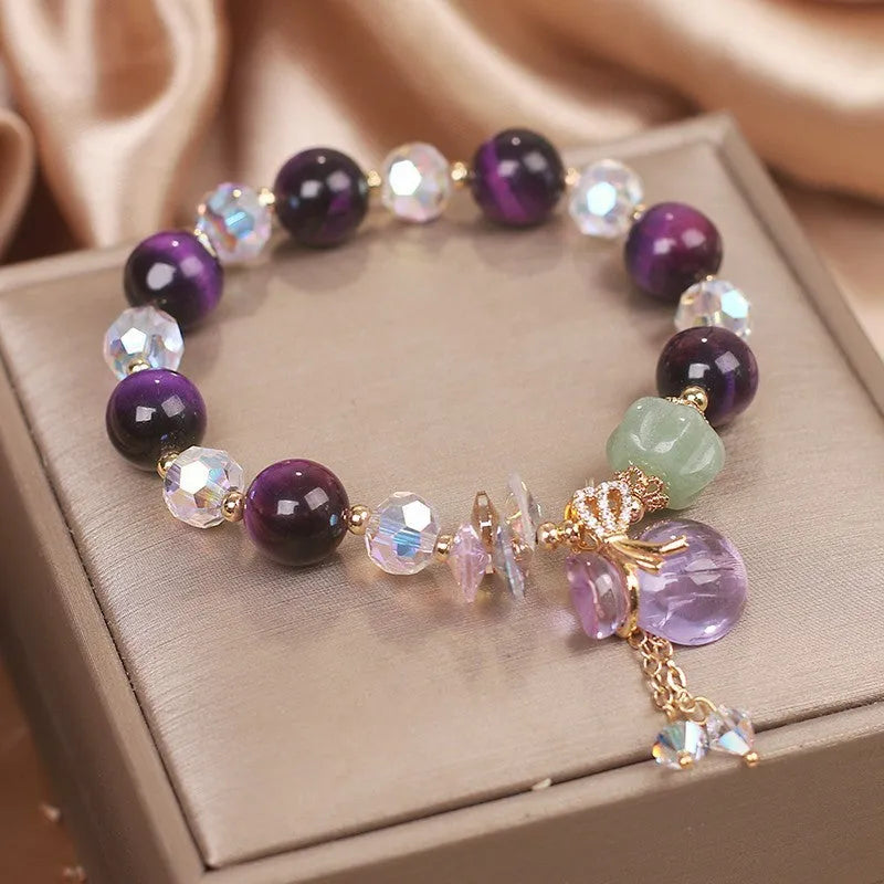 Women's crystal bracelet with purple Tigereye money bag pendant and clear rhinestone accents