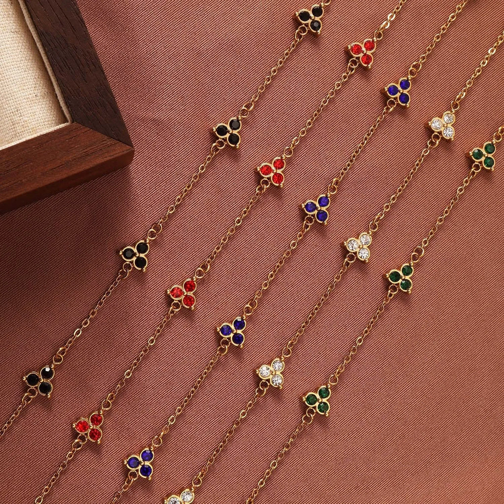 Geometric stainless steel women's bracelet with three diamond shapes and coloured stone settings.