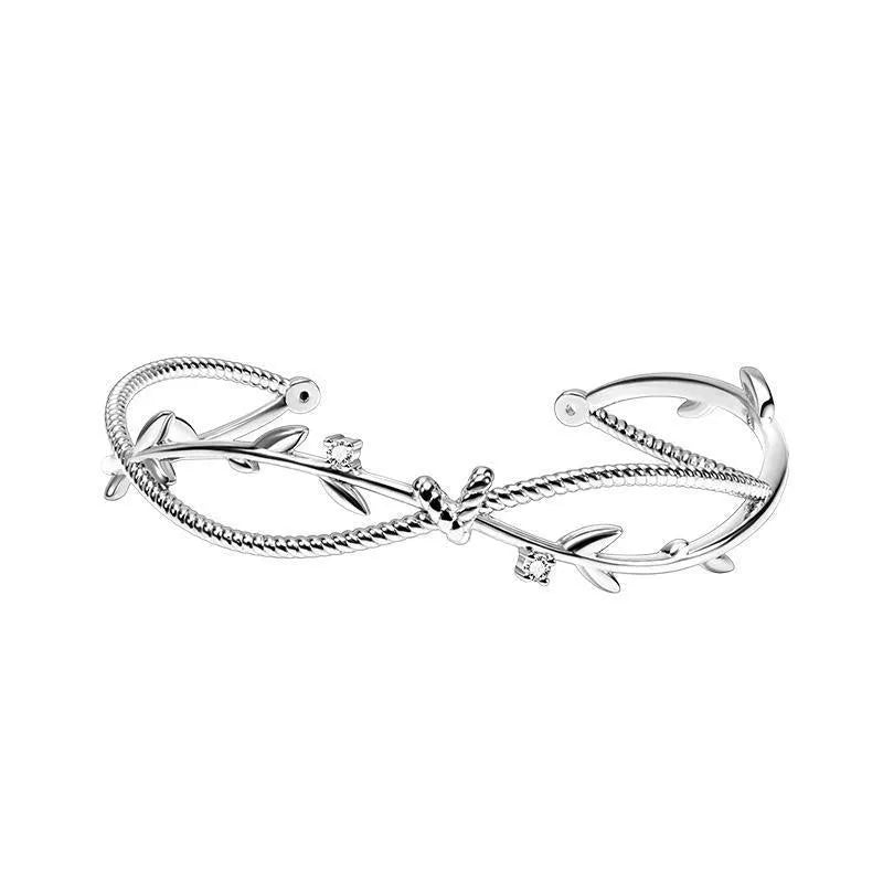 Cross twisted branch sprout bracelet in electroplated white gold Z4136 on a natural background