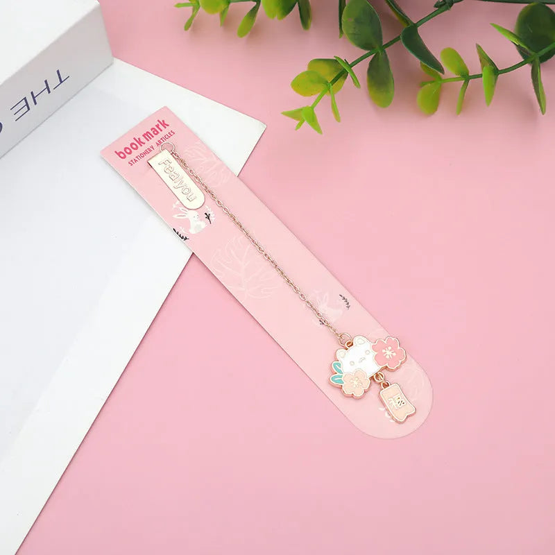 Creative cartoon metal pendant bookmark with cute cherry cat design in sakura style on white background