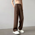 A pair of thin, straight-cut wide leg trousers in black on a hanger.
