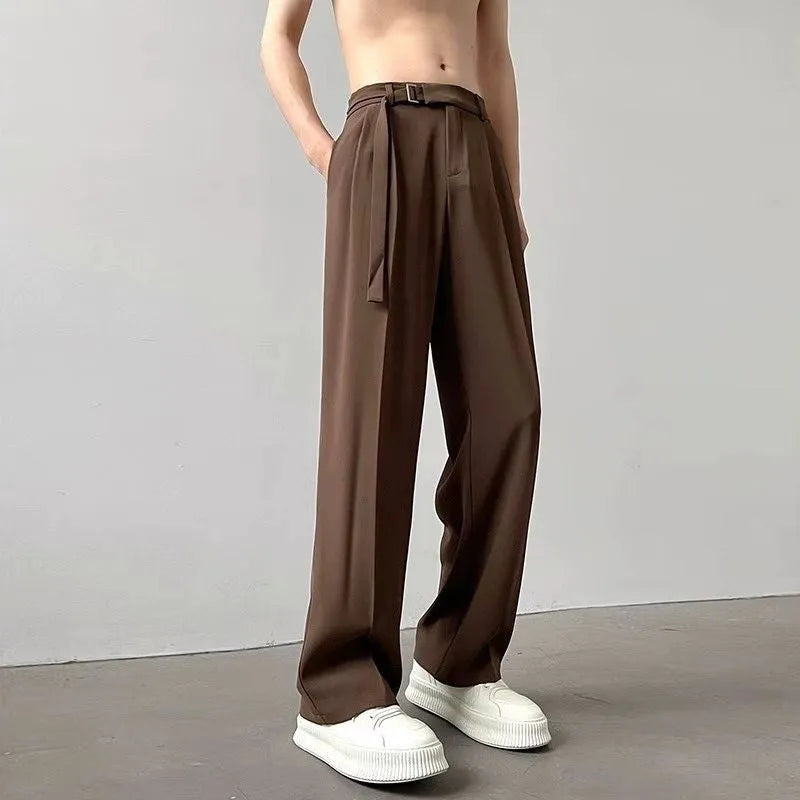 A pair of thin, straight-cut wide leg trousers in black on a hanger.