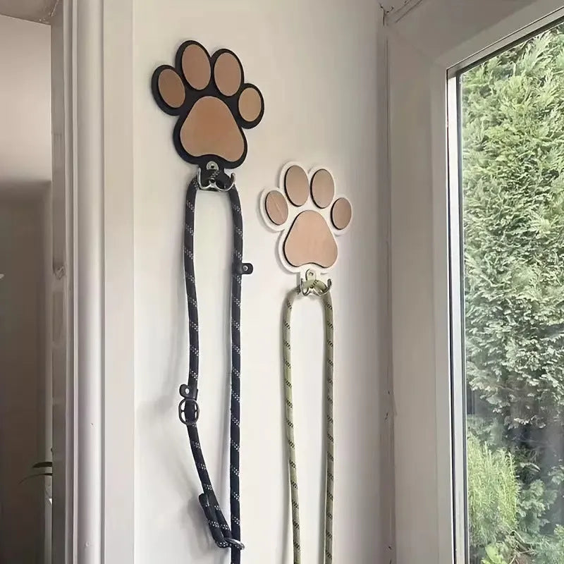 Wooden foot paw print hook in black colour on a white wall for household organisation