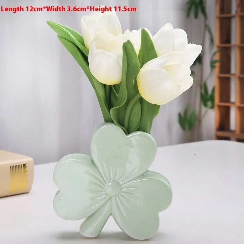 White porcelain clover ceramic vase in European style on a desktop.