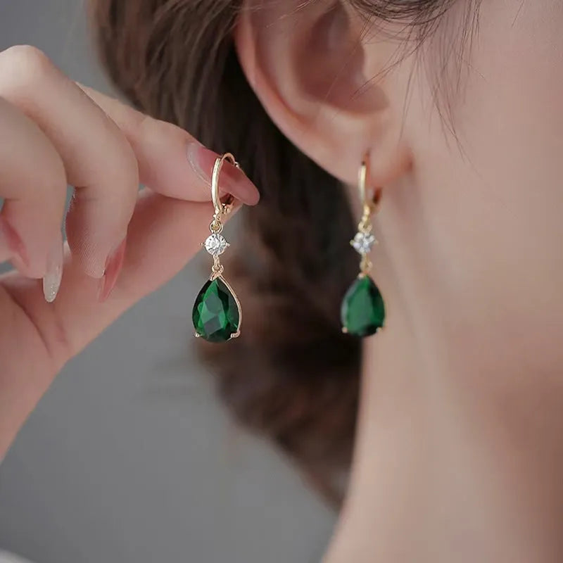 Green geometric teardrop alloy earrings with post findings on plain background