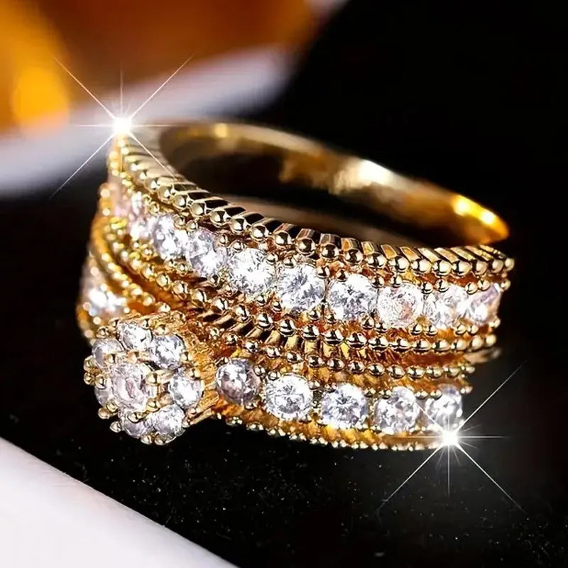 Two gold geometric zinc alloy rings with electroplated finish on white background